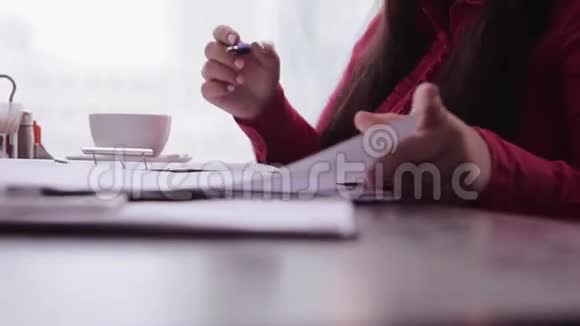 特写镜头商务妇女在办公室桌上拿着文件工作视频的预览图