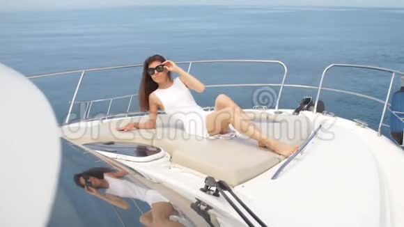 穿着白色裙子的美丽黑发女人在船上摆姿势视频的预览图