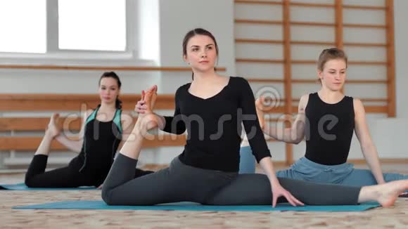 适合在健身大厅的运动垫上做瑜伽的女性视频的预览图