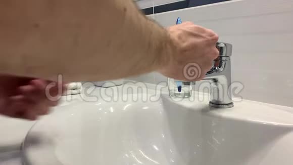 男人在浴室的水龙头下洗手视频的预览图