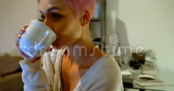 粉色头发的女人在家喝咖啡视频的预览图