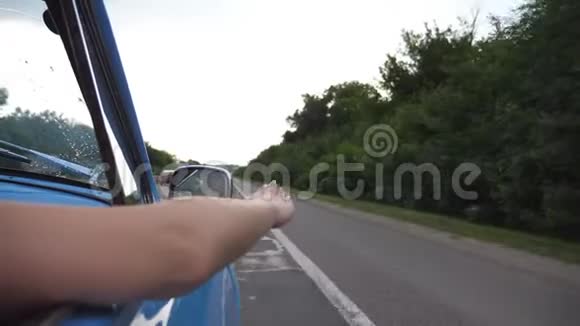 夏季旅行时复古车外的女性手臂玩风年轻女子迎风招展视频的预览图