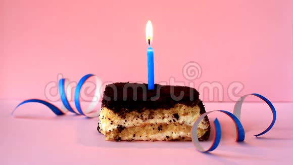 在粉红色背景上点燃蓝色蜡烛的提拉米苏蛋糕和纸屑视频的预览图