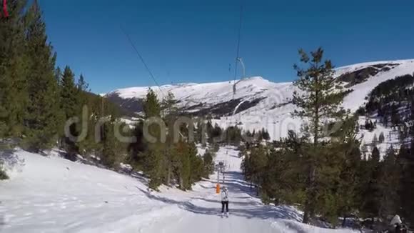 滑雪者站在滑雪台上在雪地里翻滚周围是森林视频的预览图