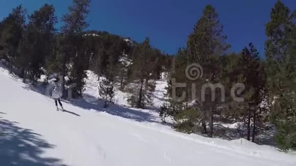 滑雪者在阳光的照射下在山上滚下一条雪道视频的预览图