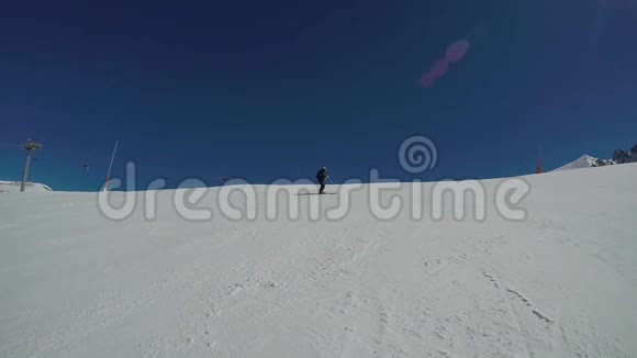 冬天山里的滑雪者沿着一条快速蜿蜒的下坡跑道滚动视频的预览图