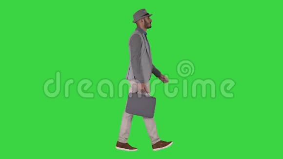 穿着休闲装的人带着公文包走在绿色的屏幕上铬钥匙视频的预览图
