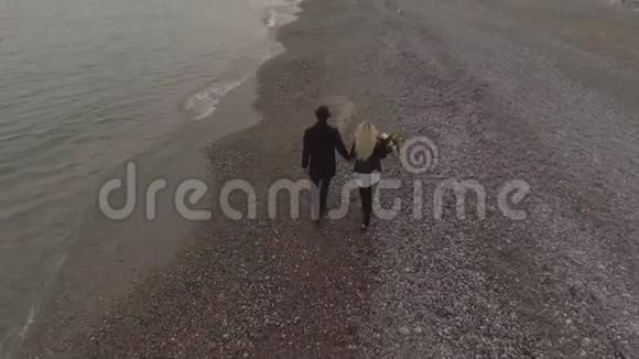 约会情侣牵着手走在海边女孩拿着花约会视频的预览图