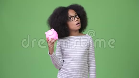 年轻可爱的非洲女孩非洲头发手里拿着储蓄罐视频的预览图