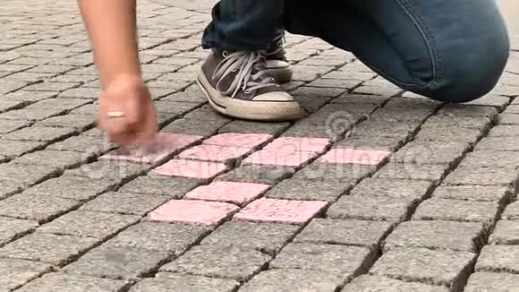 女孩用粉笔在人行道上画画视频的预览图