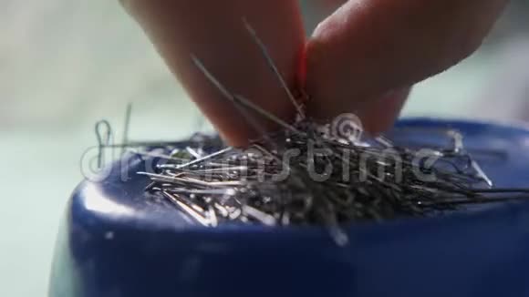特写插针手拿针刺绣图案缝制优雅婚纱的设备手工制作视频的预览图