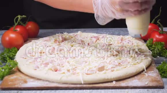 大瓶中用白酱覆盖比萨饼表面的厨师特写框架意大利比萨的制作视频的预览图