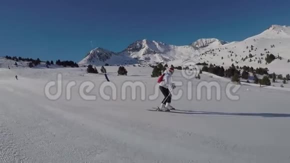 女人在山坡上滑雪阳光明媚雪山环绕视频的预览图