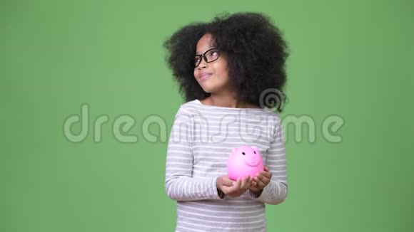 年轻可爱的非洲女孩非洲头发手里拿着储蓄罐视频的预览图