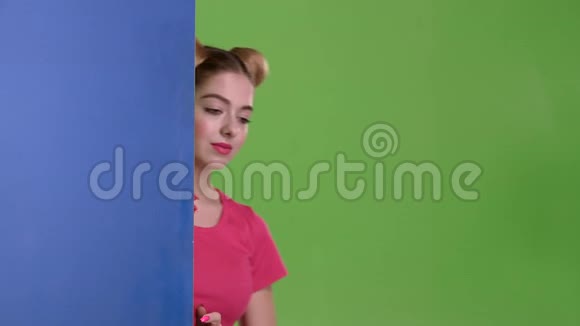 青少年从一块蓝色的木板后面偷看竖起大拇指绿色屏幕视频的预览图