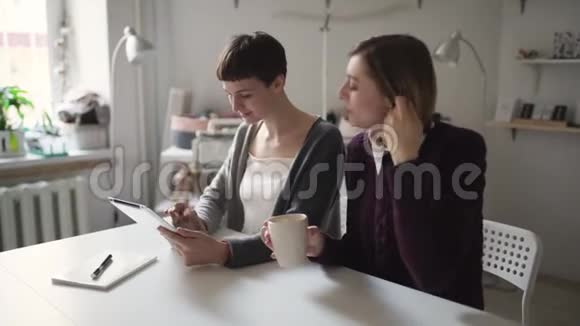 两名使用平板电脑进行家庭在线教育的女学生视频的预览图