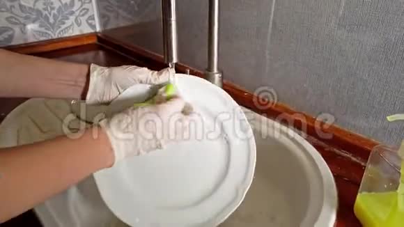 女人带着手套在厨房洗盘子视频的预览图