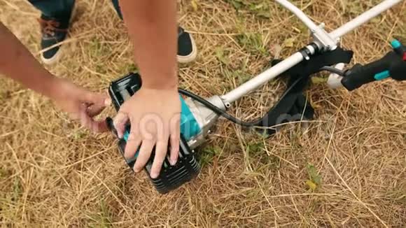 园丁男子手启动气体草坪修剪机专业割草机的手视频的预览图