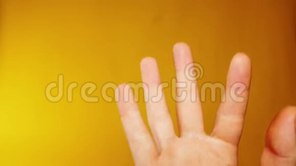 一个人的手在黄色的背景下最适合代表糟糕的派对和喜剧情况的镜头视频的预览图