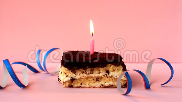 在粉红色背景上点燃蓝色蜡烛的提拉米苏蛋糕和纸屑视频的预览图