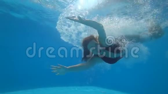 漂亮的女性在水下游泳在充满活力的环境中在背景气泡上睁开眼睛视频的预览图