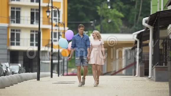 男的拿着气球女的在街上闲逛聊天浪漫的约会视频的预览图