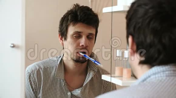 被折磨的困倦只有醒着的人在镜子前嘴里有牙刷视频的预览图