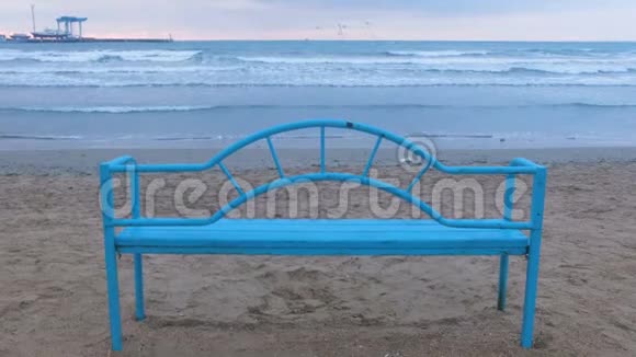 日落时沙滩上的蓝色长凳便利的基础设施可在海边放松海浪视频的预览图