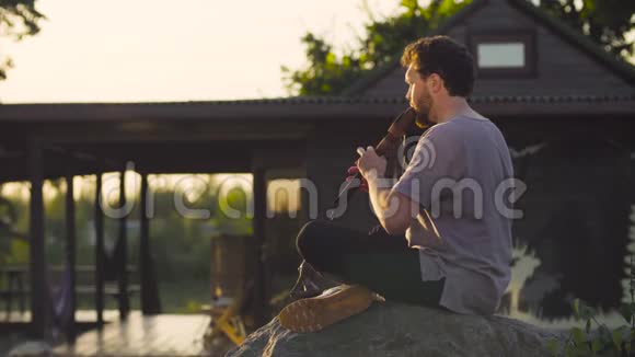一个坐在岩石上吹着民族长笛的人视频的预览图