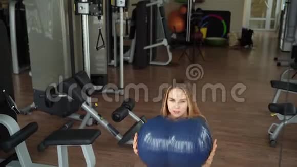 年轻女子在健身房做举重运动视频的预览图