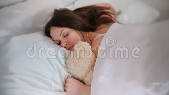 年轻的女人和玩具熊睡觉视频的预览图