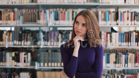 体贴的年轻女子站在图书馆的书架前视频的预览图