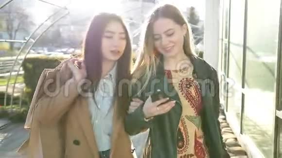 两个年轻女性在街上看智能手机视频的预览图