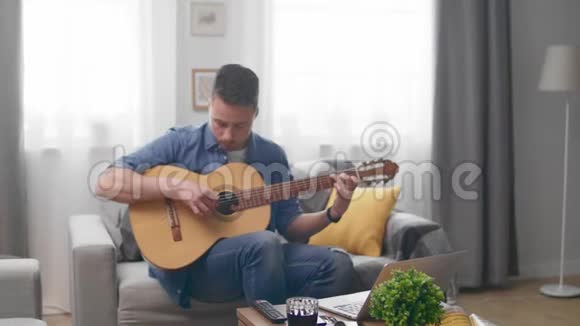 帅哥在家里沙发上弹吉他视频的预览图