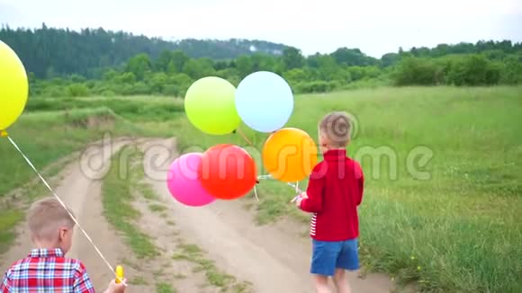 快乐的孩子们带着气球在森林路上奔跑公园里的生日庆祝活动孩子们的欢笑和欢乐视频的预览图
