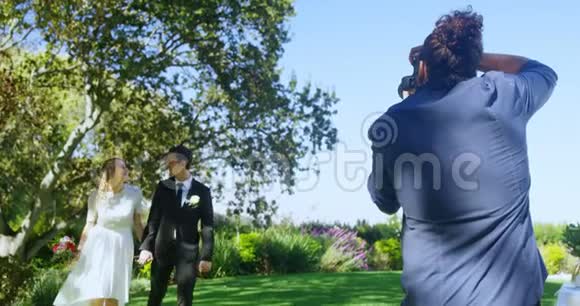 摄影师拍摄新郎新娘手牵手4K4K的照片视频的预览图