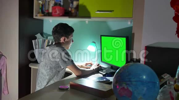 绿色钥匙室内青少年男孩玩电脑特写手游视频后坐这个男孩在电脑上工作视频的预览图