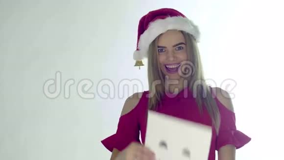 戴着红色圣诞帽的圣诞老人微笑着手里拿着一张床单幸福的微笑变成了一个孤立在白色上的悲伤的微笑视频的预览图