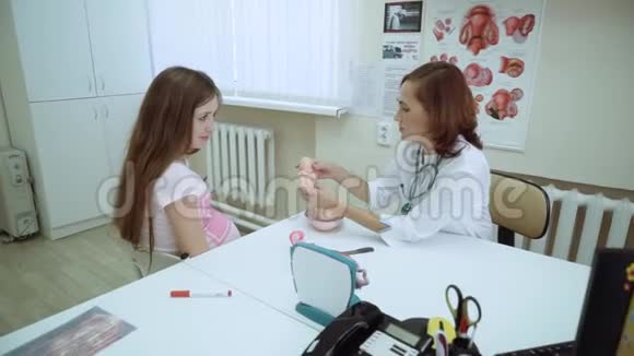 医生给怀孕的女孩看了一个胎儿发育的模型人胚胎宫内发育视频的预览图