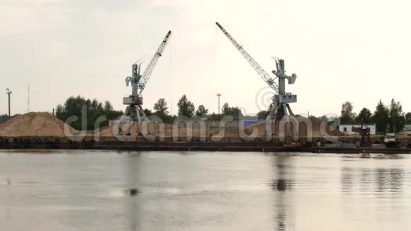 港口两台货运起重机生产河沙驳船港口视频的预览图