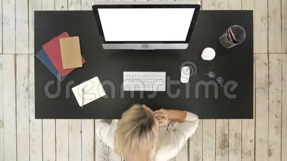 女人在电脑上工作在电话里说话白色显示器视频的预览图