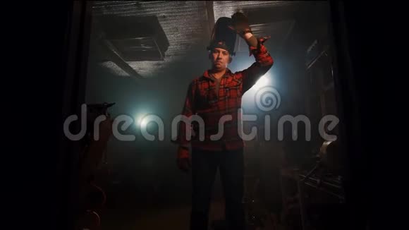 一名男子在家庭车库的焊接面罩中交叉双臂的肖像视频的预览图