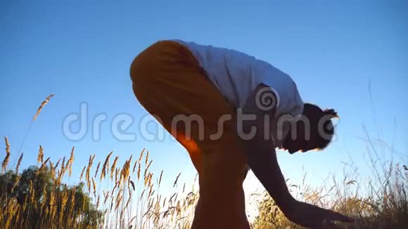 接近运动男子站在瑜伽姿势在草地上在大自然训练的人运动员在田里做运动视频的预览图