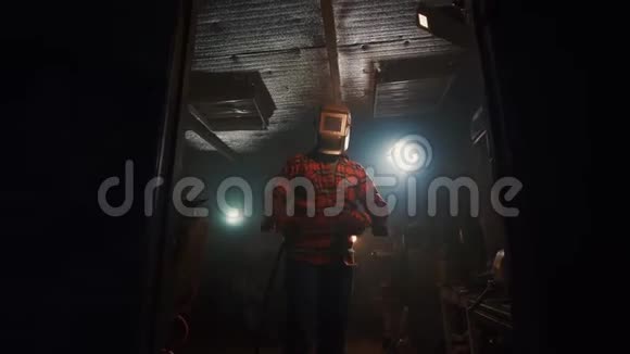 一名男子的肖像交叉双臂在家庭车库的焊接面罩准备与焊工工作视频的预览图