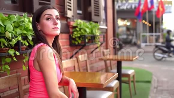 女人正在会议街上的一家咖啡馆里等人向一个4K的朋友挥手视频的预览图