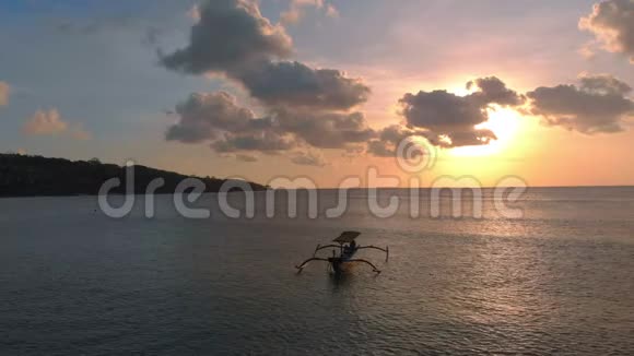 在日落时分三名渔夫船在海中的空中拍摄无人机向左移动视频的预览图