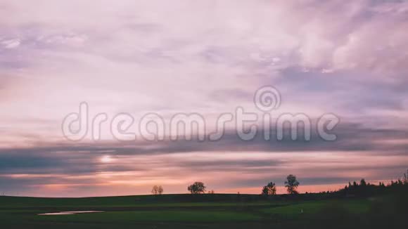 一片壮丽的日落在一片田野上云层上有粉红色的色调视频的预览图