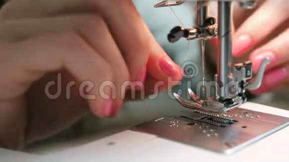 女士的手特写插入针线缝纫机中视频的预览图
