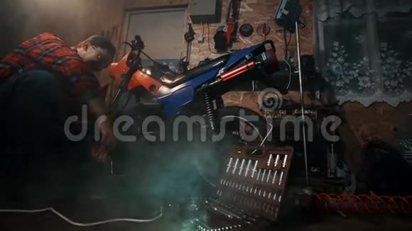 男机修工修理车库里摩托车的发动机视频的预览图