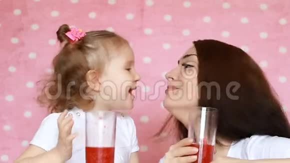 幸福的母女喝着冰沙欢欣鼓舞一位年轻女子和她的孩子的特写肖像她正在享受视频的预览图